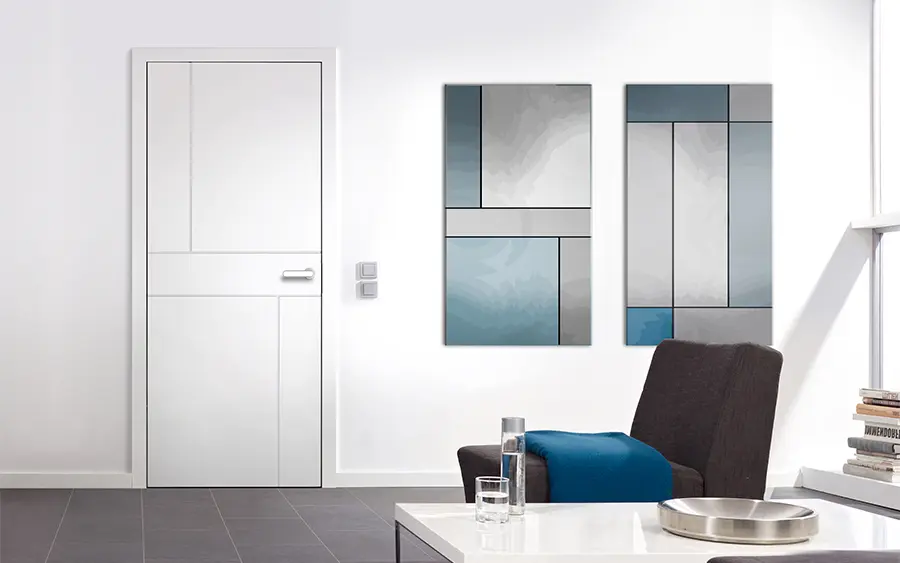 Ein moderner, minimalistischer Raum mit weißen Wänden, einer geschlossenen Groneck-Tür auf der linken Seite, zwei abstrakten blauen und grauen Wandgemälden und einem dunklen Sessel mit einem blauen Kissen neben einem kleinen