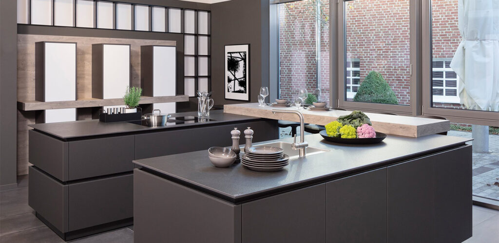 Eine moderne Küche mit eleganten schwarzen Schränken und Arbeitsplatten, einer zentralen Insel, Holzregalen, Geräten aus Edelstahl und innovativen Küchenformen.