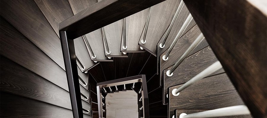 Die freitragende Treppe aus Holz von oben betrachtet zeigt die geometrischen Muster der Treppenstufen und Geländer.