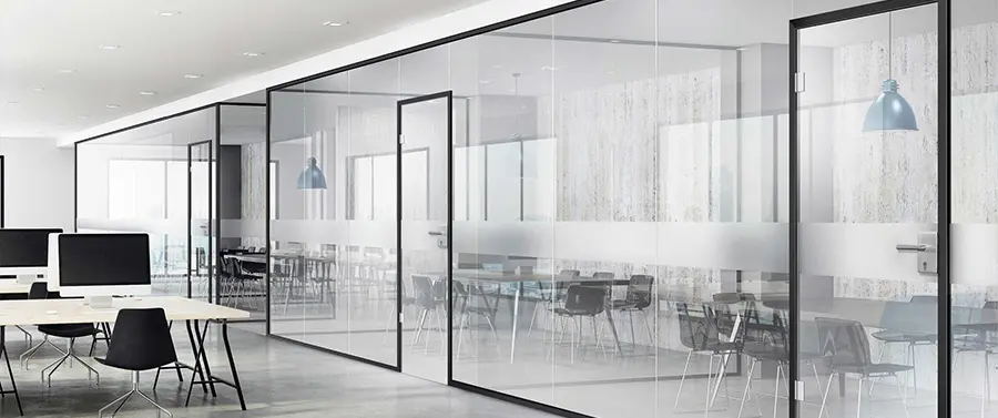 Ein moderner Büroraum mit Glastrennwänden, minimalistischem Möbeldesign und eleganten Türgriffen.