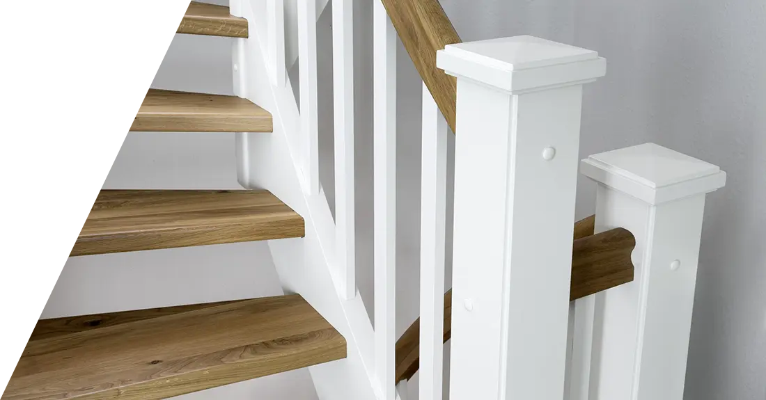 Eine Holztreppe mit weißen Geländerstäben und naturbelassenen Stufen vor einer weißen Wand, hergestellt aus ausgewählten Treppenmaterialien.