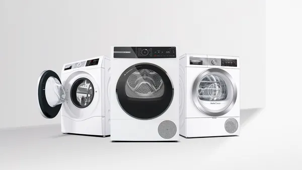 Ein Set aus drei weißen modernen Waschmaschinen von Bosch, darunter zwei Waschmaschinen mit angelehnter Frontladetür und einem geschlossenen Trockner auf neutralem Hintergrund.