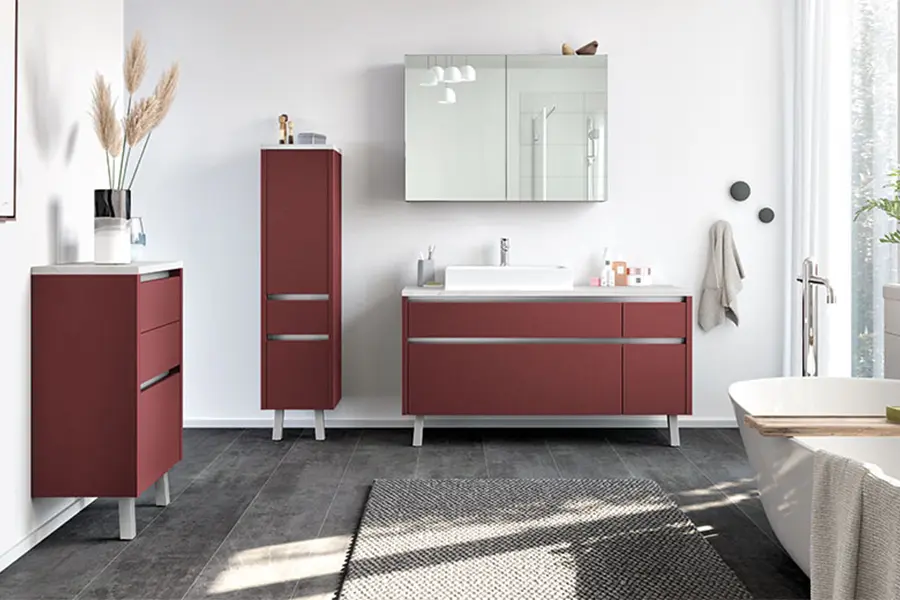Moderne Badeinrichtung mit roten Waschtischschränken, einem weißen Becken, einem großen Spiegel und minimalistischer Dekoration.