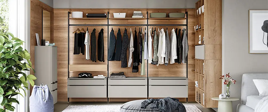 Offener Kleiderschrank mit ordentlich organisierter Kleidung und Accessoires in einer modernen, harmonische Einrichtung im Schlafzimmer.