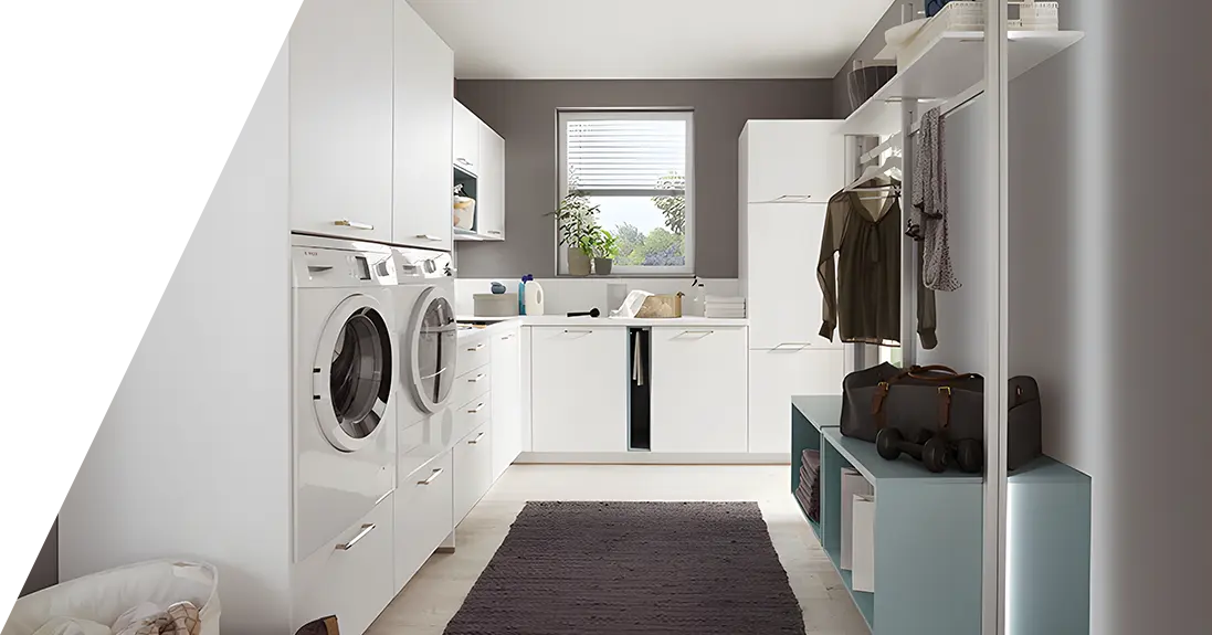 Ein moderner Waschraum mit Waschmaschine und Trockner, weißen Schränken und einem kleinen Fenster für natürliches Licht.
