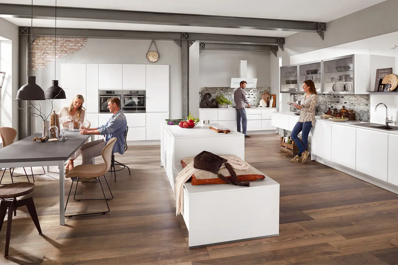 Moderne Küche mit vier Erwachsenen, die in ihrer individuellen Küche verschiedenen Aktivitäten nachgehen, darunter Essen, Kochen und Gespräche.