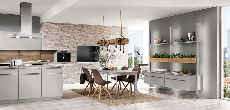 Moderner Küchen- und Essbereich mit eleganten grauen Schränken, Küchengeräten aus Edelstahl, einer Akzentwand aus Stein und einem Holztisch mit Stühlen unter Pendelbeleuchtung sowie einem elegant integrierten Regalsystem für zusätzlichen Komfort