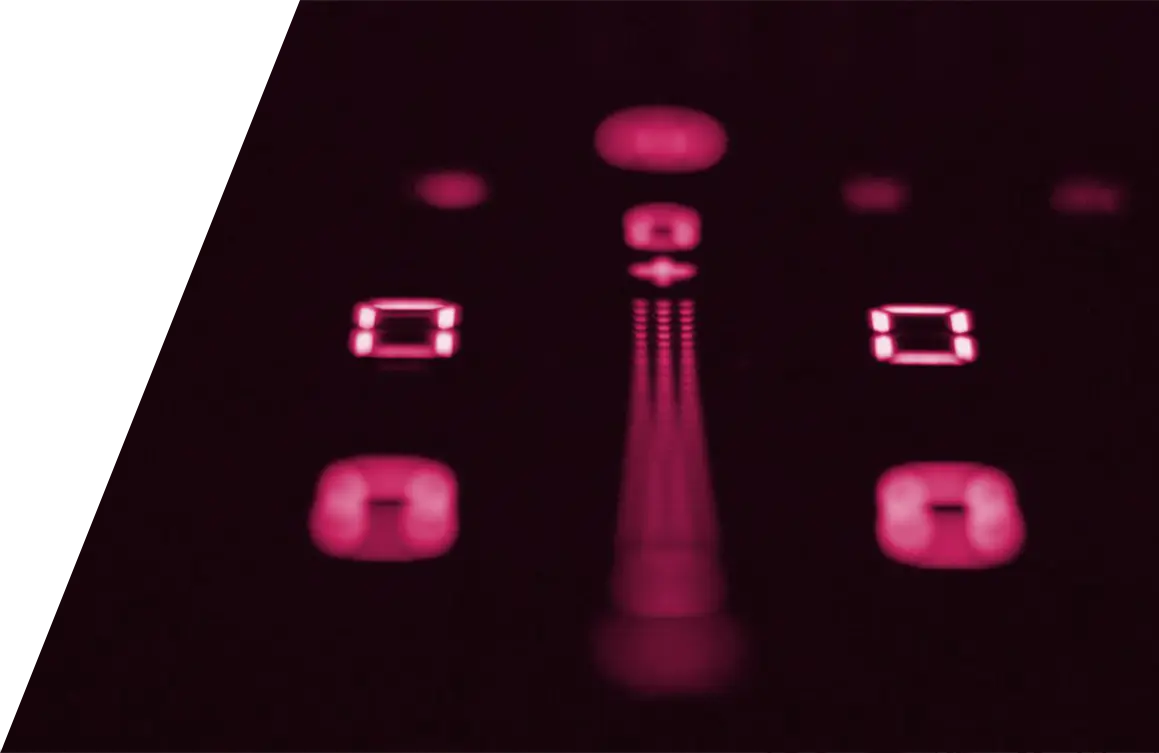 Eine Nahaufnahme von Tasten elektronischer Geräte, die durch rote Hintergrundbeleuchtung beleuchtet werden, wobei eine geringe Schärfentiefe den größten Teil des Bildes verwischt, einschließlich der Merkmale von Bora Kochfeldabzügen.