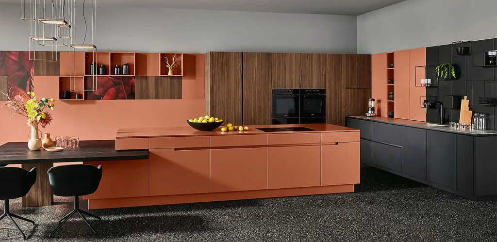 Moderne Küche mit einer zentralen Insel und integrierten Bora-Kochfeldabzügen, mit kontrastierenden orangefarbenen und dunkelgrauen Schränken, Holzakzenten und eleganten Designelementen.