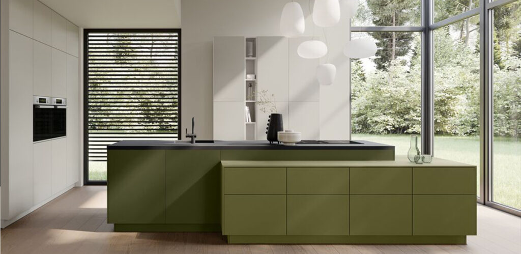 Eine moderne Design-Küche mit olivgrünen Schränken, einer zentralen Kücheninsel und Einbaugeräten, mit Blick ins Freie durch große Glasfenster.