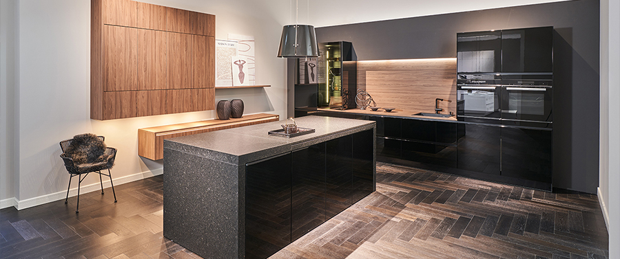Moderne Küche mit elegantem Design, zentraler Kochinsel, individuellen schwarzen Arbeitsplatten, Holzschränken und Einbaugeräten.
