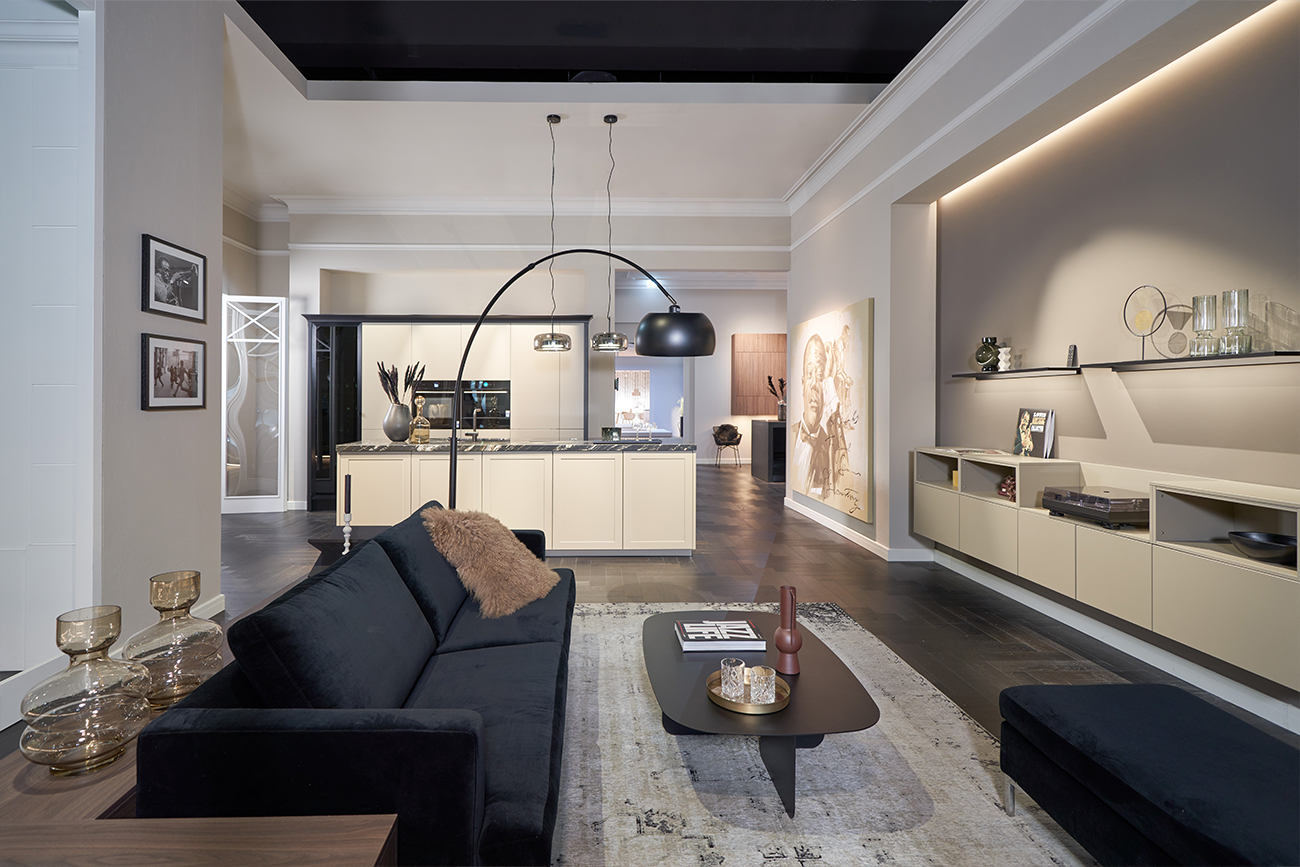 Ein modernes und stilvolles Wohnzimmer, nahtlos verbunden mit einer individuellen Küche, mit eleganten Möbeln, schicken Beleuchtungskörpern und einer neutralen Farbpalette mit warmen Akzenten.