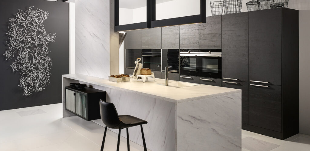 Moderne Küche mit eleganten schwarzen Schränken, Marmorarbeitsplatten und einer dekorativen Wandzeichnung mit verschiedenen Küchenstilen.