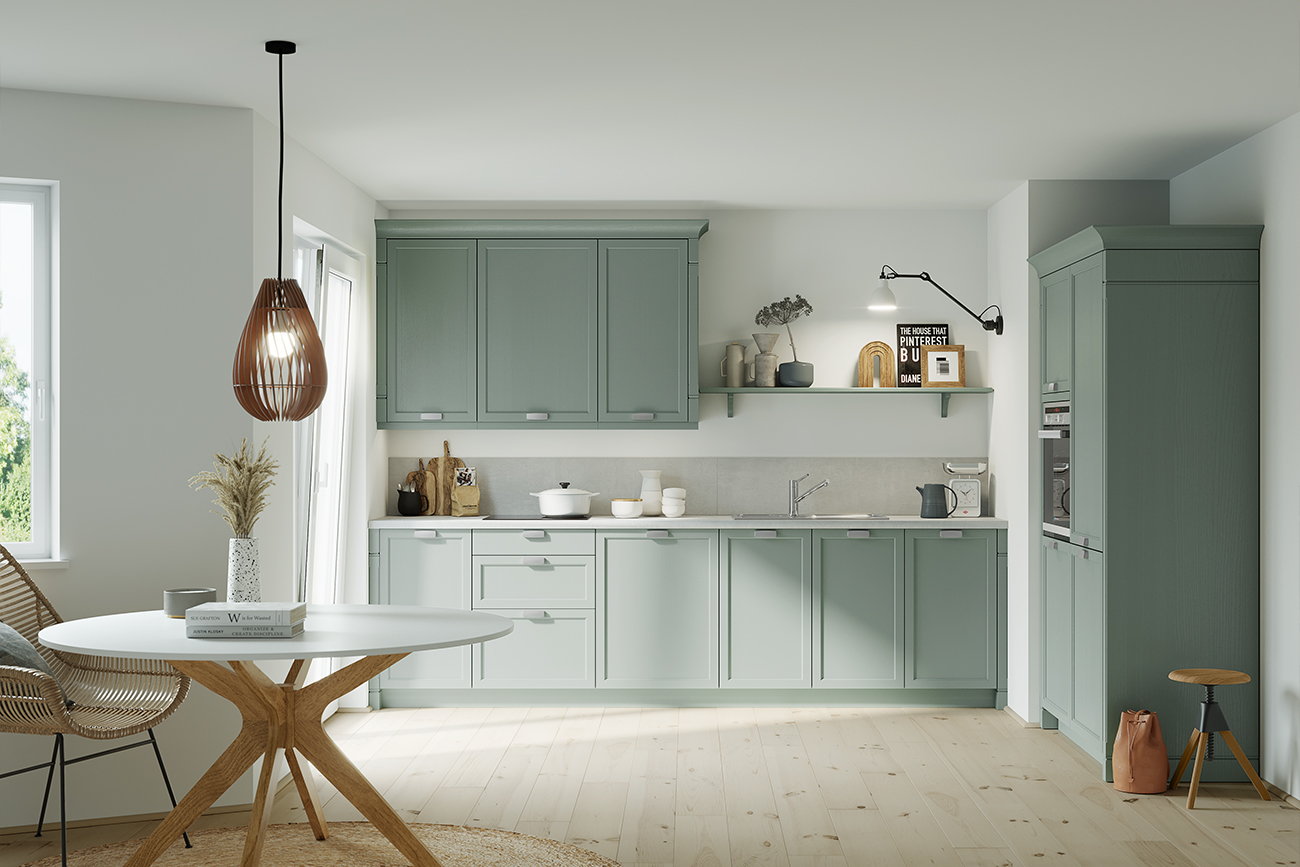 Von Landhausküchen inspiriertes modernes Kücheninterieur mit blaugrünen Schränken, Geräten aus Edelstahl und einem Esstisch aus Holz vor einer neutralen Farbpalette.
