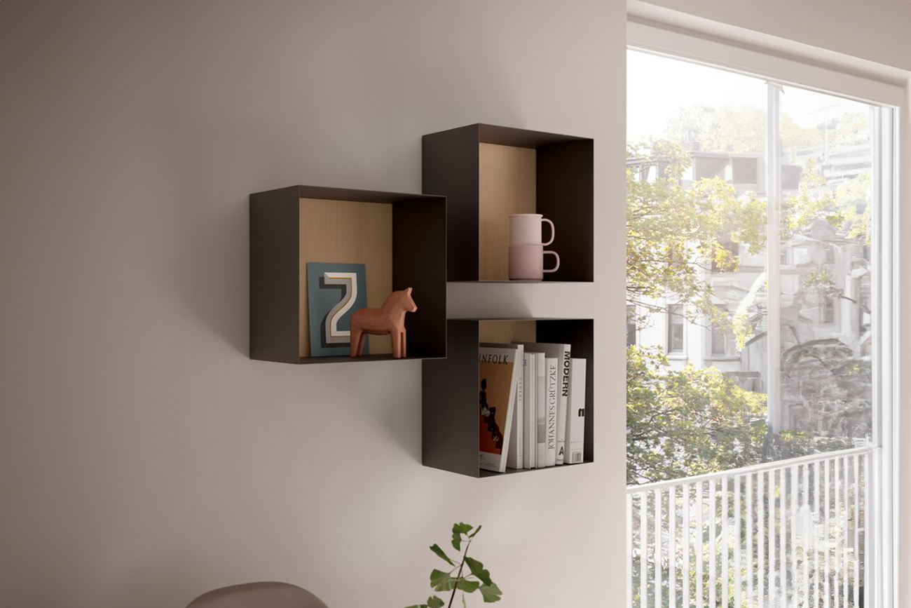 Ein Set aus zwei Wandregalen mit Wohnzimmereinrichtungsgegenständen, darunter eine Figur, eine Tasse und Bücher, in einem Raum mit einem Fenster, das einen Ausblick bietet